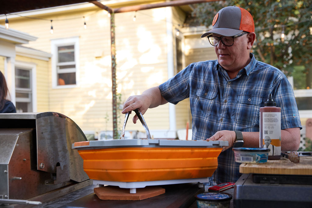 Man at grill using prep tub