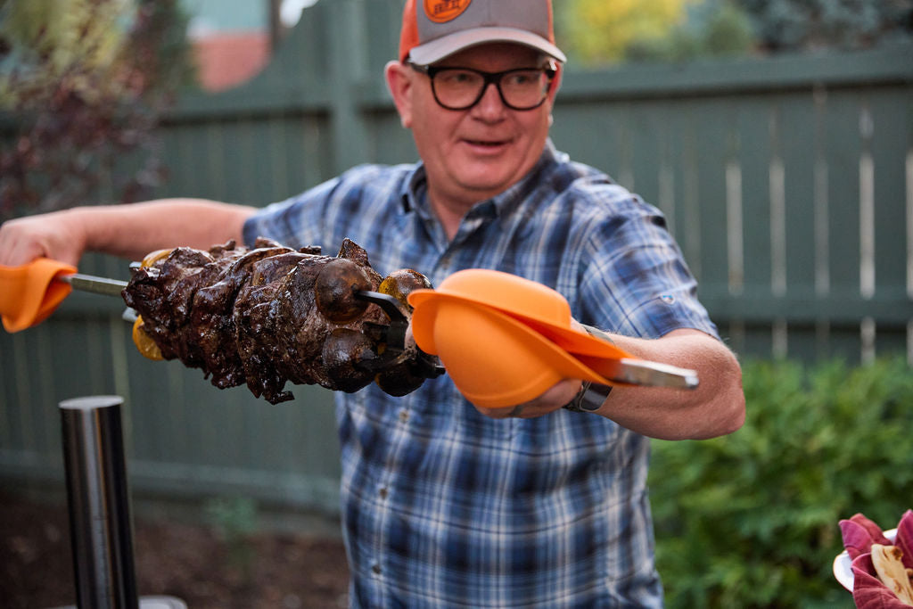 Grill mitts in use on meat