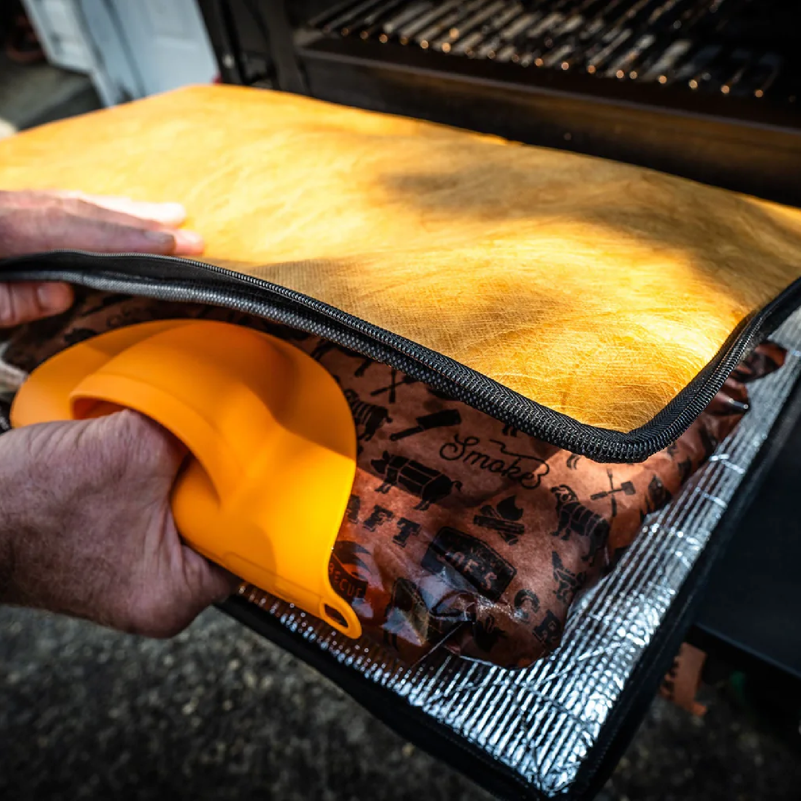 Grill mitts pulling meat out of resting blanket