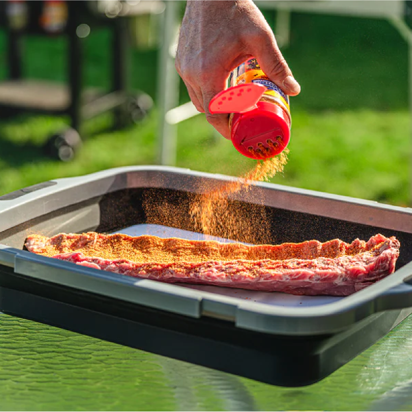 Rub being poured on meat in prep tub