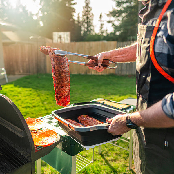 Prepped meat out of prep tub onto the grill
